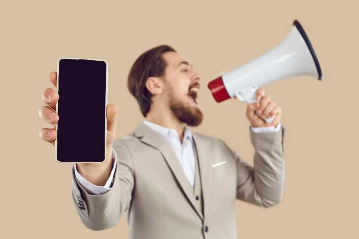 Uomo con megafono e smartphone