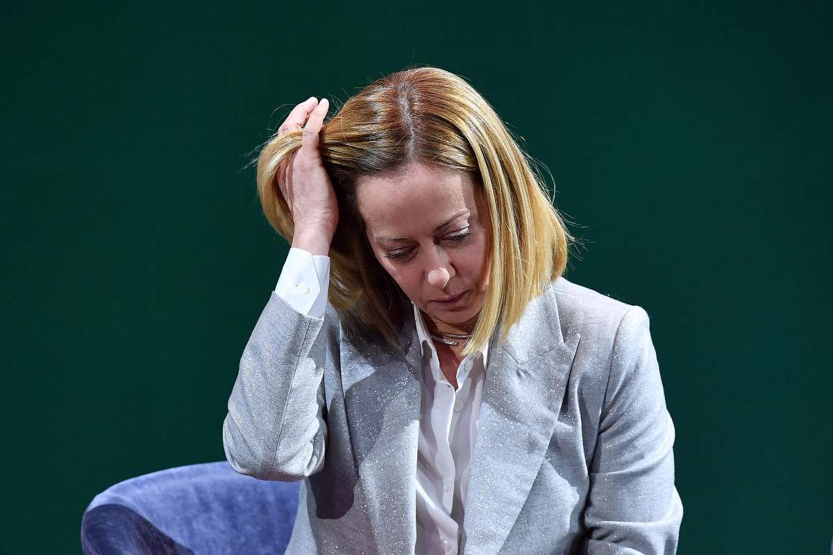 giorgia meloni con mano tra i capelli
