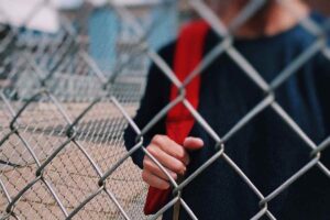 bambino fuori dalla scuola cancello chiuso
