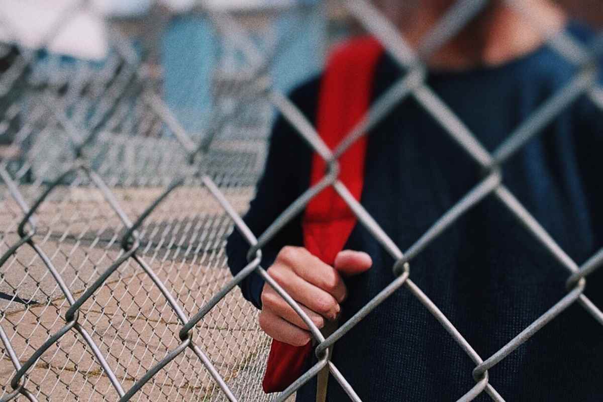 bambino fuori dalla scuola cancello chiuso