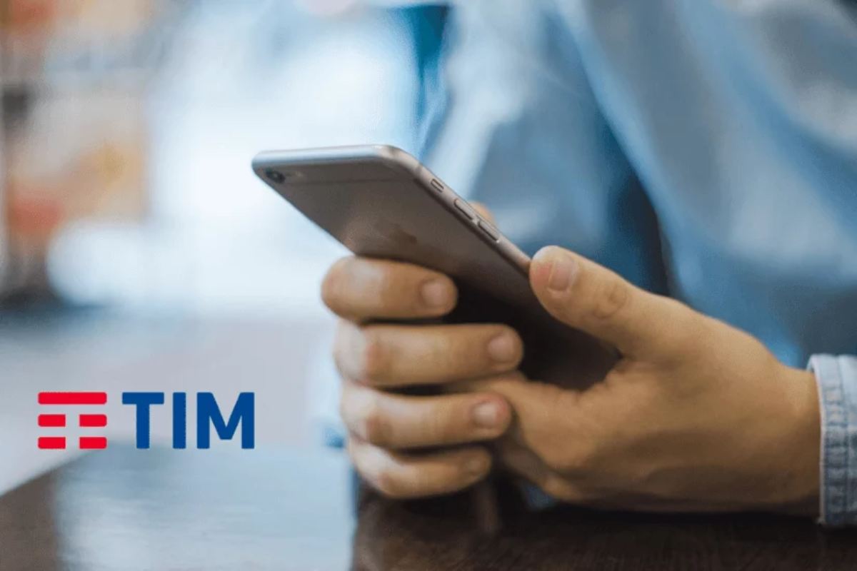 uomo tiene cellulare in mano e scritta tim