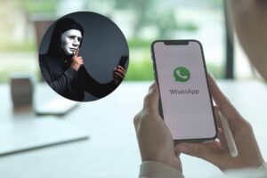 mani tengono cellulare con la scritta whatsapp e nel riquadro truffatore con cellulare