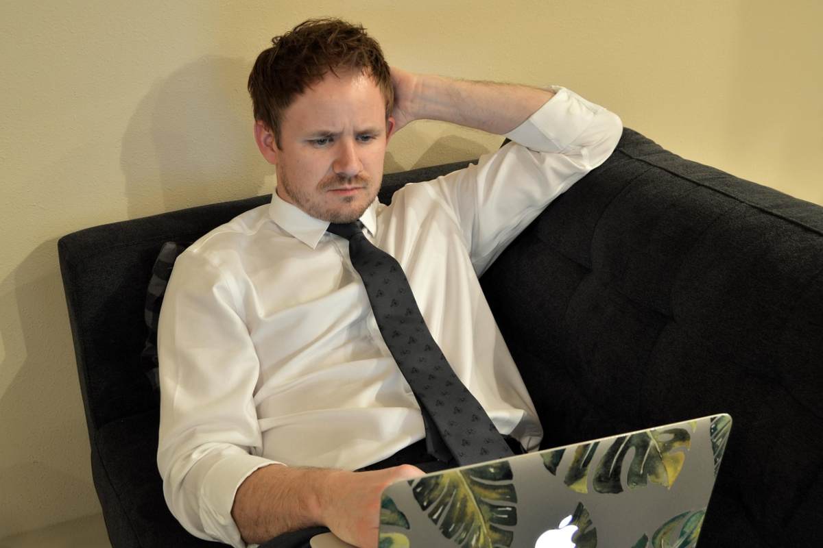 uomo sul divano con il computer sulle gambe