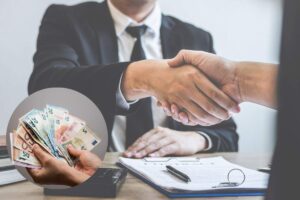 impiegato banca stringe la mano a cliente e nel riquadro banconote