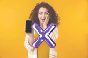 una ragazza con uno smartphone e una x