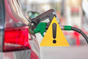 pompa di benzina dentro auto e segnale pericolo