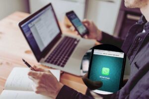 un ragazzo tra computer e smartphone con whatsapp in un cerchietto