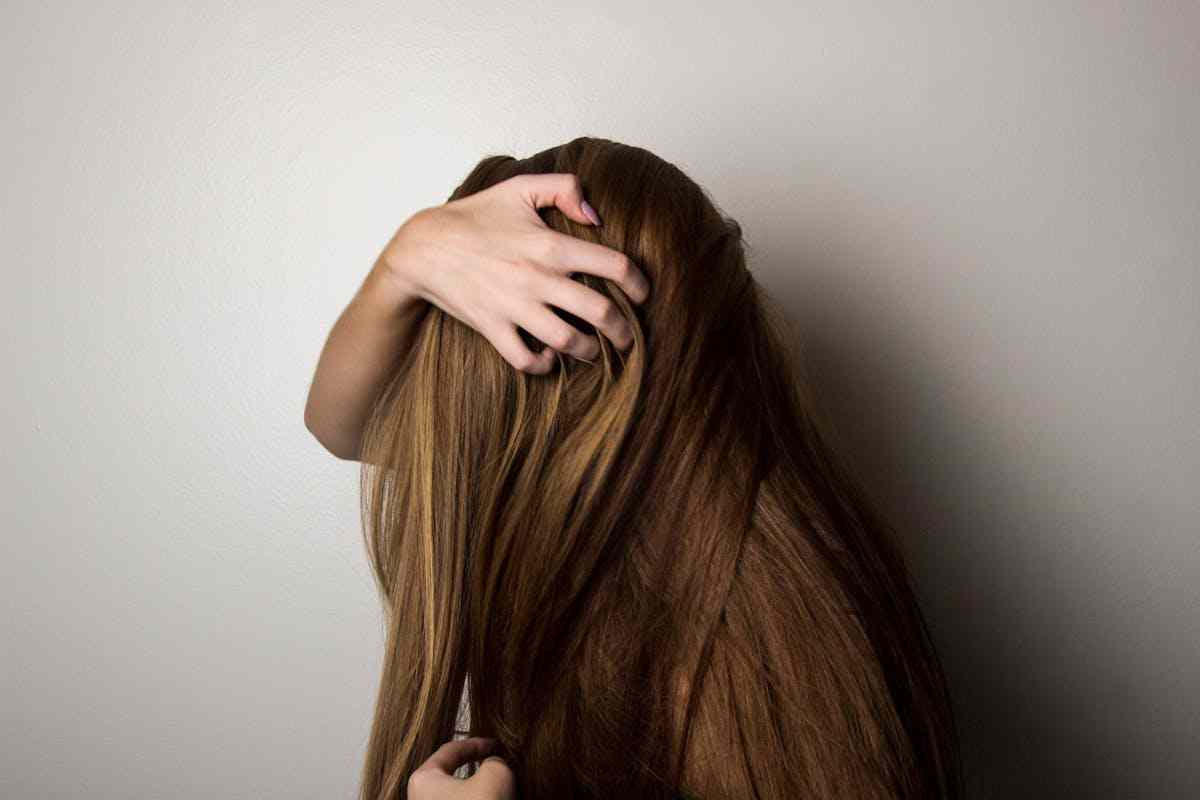 donna con mano nei capelli