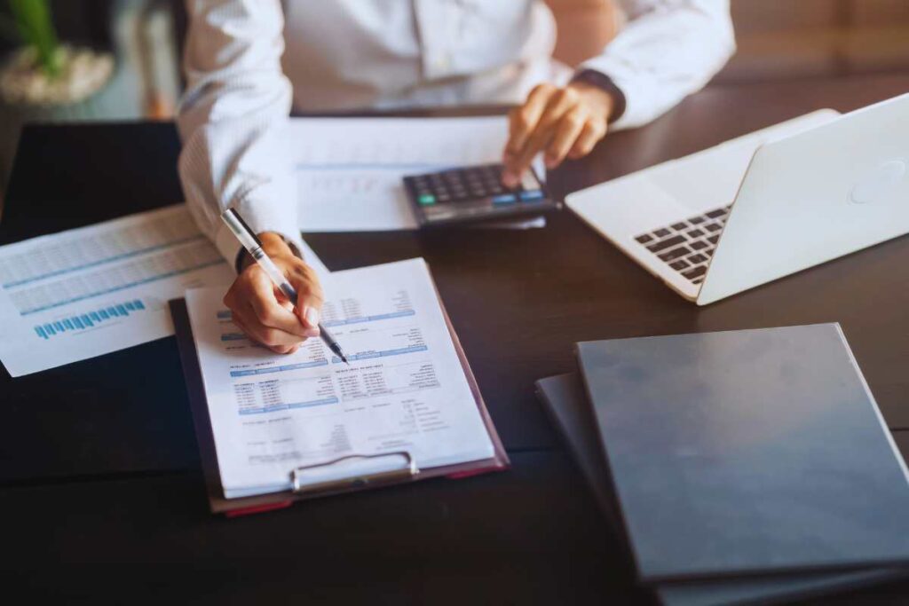 Uomo ad una scrivania che lavora su dei fogli di carta